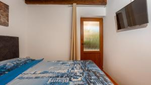 een slaapkamer met een bed en een flatscreen-tv bij Vila Gostinjac 2 with pool Krk by Villas Guide in Gostinjac