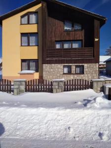een gebouw met een hek in de sneeuw bij Sárka in Štrba