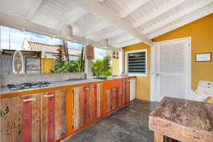 een open keuken met houten kasten en een tafel bij Barefoot Bonaire in Kralendijk