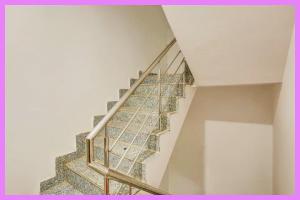 eine Treppe mit Metallgeländer in einem Haus in der Unterkunft Hotel Renvlux Premium Stay in Puri