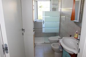een kleine badkamer met toilet en wastafel bij A Casuzza di Pina e Raffaele in Villaggio Azzurro