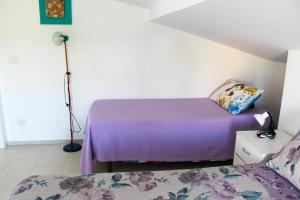 een slaapkamer met een bed met paarse lakens en een lamp bij A Casuzza di Pina e Raffaele in Villaggio Azzurro