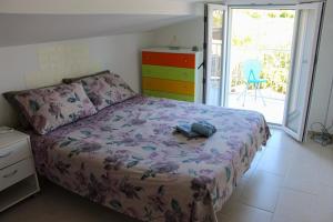 een slaapkamer met een bed met een paars dekbed en extra's bij A Casuzza di Pina e Raffaele in Villaggio Azzurro