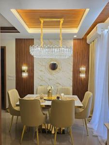 ein Esszimmer mit Tisch und Stühlen und einem Kronleuchter in der Unterkunft LS Luxurious apartment with cosy stay in Thiruvananthapuram + 27 Fotos