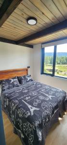 a bedroom with a black and white bed with a window at Carrusel in Trape