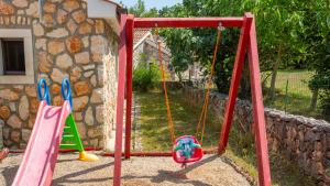 een schommel in een tuin met twee schommels bij Vila Gostinjac 2 with pool Krk by Villas Guide in Gostinjac