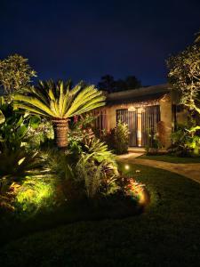 a house with lights in the yard at night at Widji Garden Villa in Uluwatu