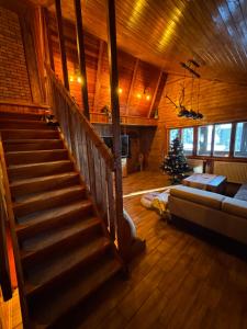a living room with a staircase in a cabin with a christmas tree at Chata - TYROLEHAUSE in Martin +21 photos