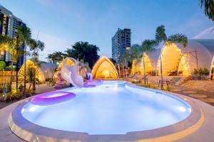 een groot zwembad in een stad 's nachts bij Camping&Cafe Khao Phratamnak in Pattaya South