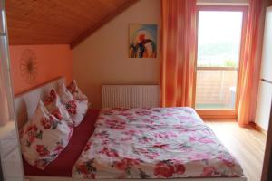 a bedroom with a bed with a floral bedspread and a window at Haus zur Sonne in Sankt Urban