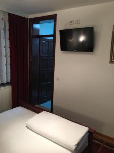 a room with two beds with a mirror and a television at Vila Lux Milikic in Kraljevo