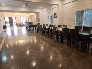 una sala da pranzo con un lungo tavolo e sedie di Easty a Bangalore Altre 79 foto