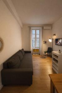 ein Wohnzimmer mit einer Couch und einem Fenster in der Unterkunft Studio Moderne, Le Carré Dor, À 3min Plage, NICE CENTRE in Nizza