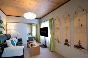 a living room with a couch and a tv at Powder Snow 粉雪 in Furano