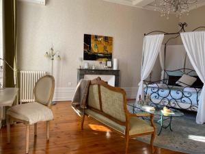 a living room with a bed and a table and chairs at Le Relais d'Angély in Saint-Jean-dʼAngély