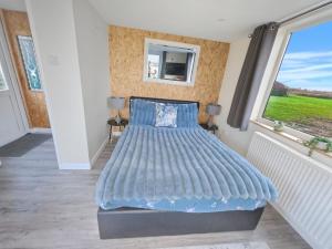 Meysey HamptonLakeview at The Hideaway的有大窗户的房间里的一张床