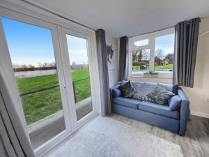 Meysey HamptonLakeview at The Hideaway的带沙发和大窗户的客厅 更多1张照片