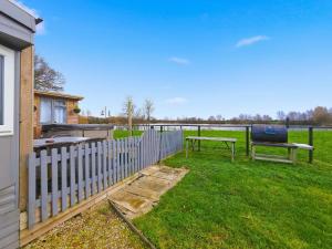 Meysey HamptonLakeview at The Hideaway的院子中带桌子和长凳的围栏