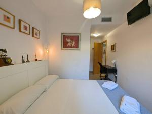 a bedroom with a large white bed in a room at Relax en Lloret con Gym y Piscina by Host&Joy in Lloret de Mar