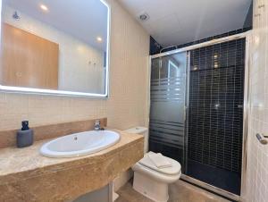 a bathroom with a sink and a toilet and a shower at Relax en Lloret con Gym y Piscina by Host&Joy in Lloret de Mar +6 photos