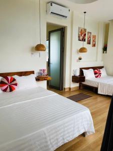 a bedroom with two beds and a door to another room at Khách Sạn Trung Loan in Ninh Hải