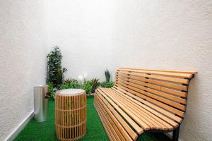 a wooden bench and a trash can next to a wall at Liora Boutique in Riyadh