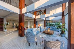 an open living room with blue couches and chairs at Valley View 5-BHK Villa With Private Pool, Sit-out Areas, TT Table, Pool Table , Bar & Scenic Views in Mapusa