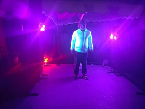 a man standing in a dark room with red lights at Woody Trails - Astronomy, Graphology, Family, Kainchi Dham in Bhowāli