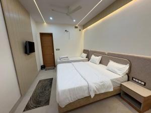 a bedroom with a large bed and a television at Shri Radha Krishnam in Barsāna