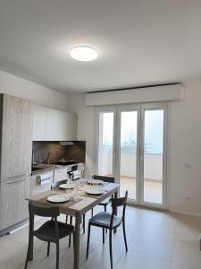 een keuken met een tafel met vier stoelen en een keuken met uitzicht bij Cantico del Mare in Recanati +38 foto's