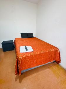 een bed met een oranje laken erop bij Monaco - Habitacion Mollendo in Inclán