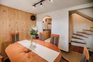 a dining room table with a vase of flowers on it at Traditional Slovenian House Pr'Belej in Zgornje Gorje +40 photos
