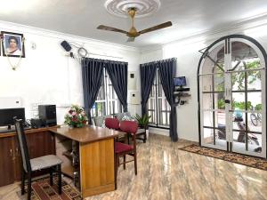 an office with a desk and chairs and a ceiling fan at Sonnetta Residency in Cochin