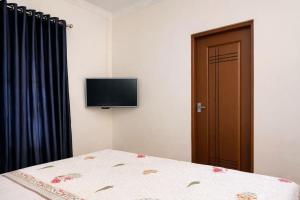 a bedroom with a bed and a flat screen tv at Sonnetta Residency in Cochin