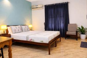 a bedroom with a bed and a desk and a chair at Sonnetta Residency in Cochin +13 photos