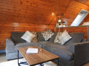 een woonkamer met een bank en een tafel bij Cear 2- Private Hot Tub- Perth-Pet Friendly Lodge in Almondbank