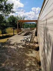 einen Tisch und Stühle auf einer Terrasse neben einem Gebäude in der Unterkunft La Belle Vue in Durmignat