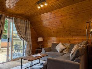 een woonkamer met een bank en een tafel bij Cear 2- Private Hot Tub- Perth-Pet Friendly Lodge in Almondbank +10 foto's