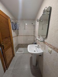 ein Badezimmer mit Waschbecken, Spiegel und Dusche in der Unterkunft Hotel Santa María in Palos de la Frontera