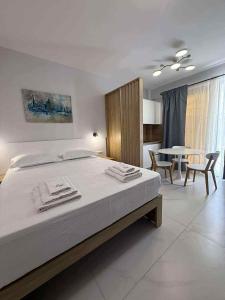 une chambre avec un lit, une table et des chaises dans l'établissement N apartments, à Néa Péramos