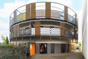 ein rundes Gebäude mit einem Balkon an der Seite in der Unterkunft Subtle Apartment in Poznań with Parking Close to the Airport by Noclegi Renters in Posen