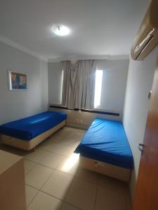 ein Zimmer mit zwei Betten und einem Fenster in der Unterkunft Apart Flat Aguas da Serra in Rio Quente
