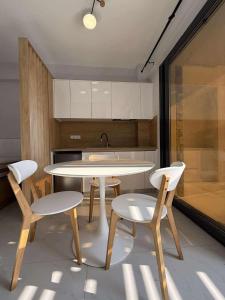 - une cuisine avec une table, 2 chaises et un évier dans l'établissement N apartments, à Néa Péramos