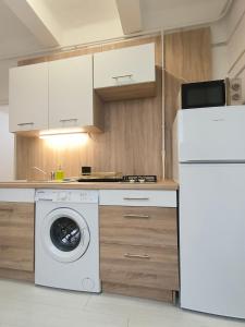 a kitchen with a washing machine and a refrigerator at GrandPa Delux in Miskolc