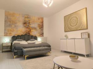 a bedroom with a bed and a table in it at GrandPa Delux in Miskolc