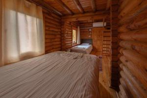 a bedroom with a bed in a log cabin at OBA KÜTÜK EVLERi in Seben +88 photos