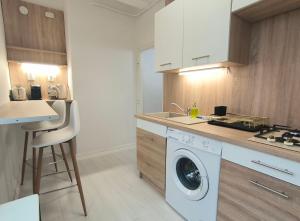 a kitchen with a washing machine and a sink at GrandPa Delux in Miskolc +14 photos