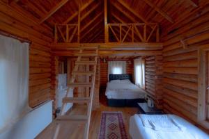 a bedroom with two beds and a ladder in a log cabin at OBA KÜTÜK EVLERi in Seben