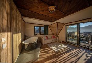a bathroom with a tub and a couch and window at Apartamenty Premium Rysulówka in Kościelisko