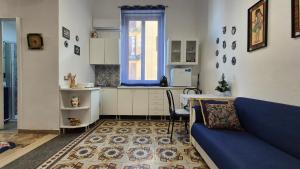 a living room with a blue couch and a kitchen at AA Central Station Historical center in Palermo